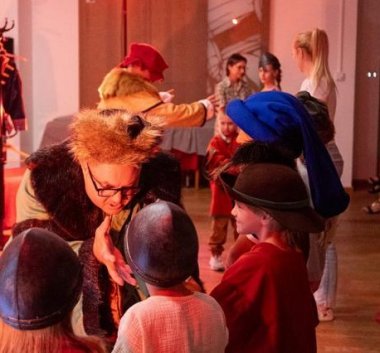 Kolorowa fotografia. Aktorzy i dzieci w kostiumach teatralnych.