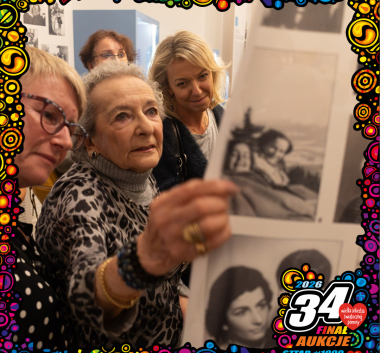 Osoby zwiedzające wystawę. Logo WOŚP.