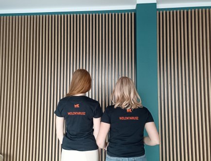 Kolorowa fotografia. Dwie osoby w koszulkach z napisem: Muzeum Krakowa Wolontariusz