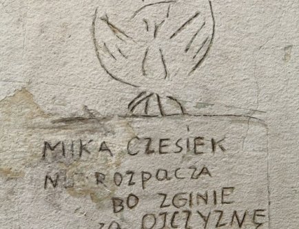 Fotografia wyrytego na ścianie rysunek orła w koronie. Pod spodem napis: „Czesiek Mika nie rozpacza bo zginie za ojczyznę. 4 stycznia 1945”