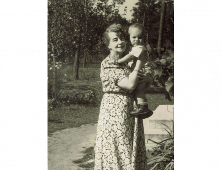 Czarnobiała fotografia. Kobieta trzymająca na rękach dziecko.