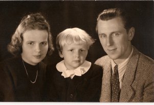 Portretowa fotografia czarnobiała. Młoda kobieta, w środku 3 letni chłopiec i młody mężczyzna.