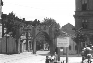 Czarnobiała fotografia przedstawiająca bramę do Getta w Krakowie.